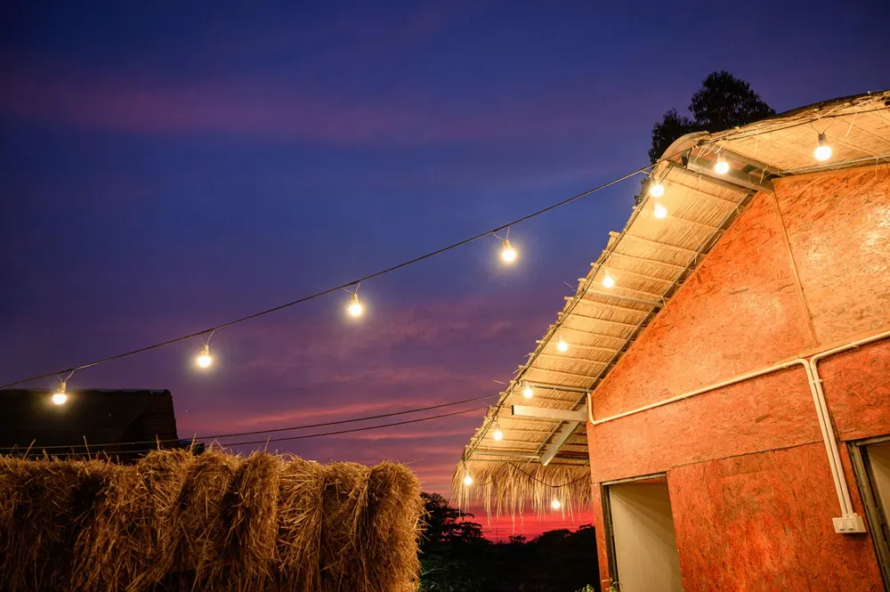 Warm string lighting over an outdoor structure at dusk